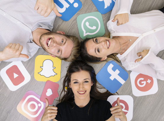young-smiling-friend-lying-floor-with-social-media-logos-showing-thumbup-sign.jpg