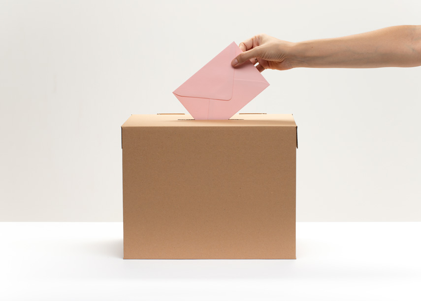 VOTE -hand-puts-pink-envelope-into-vote-bo-855pxx.jpg