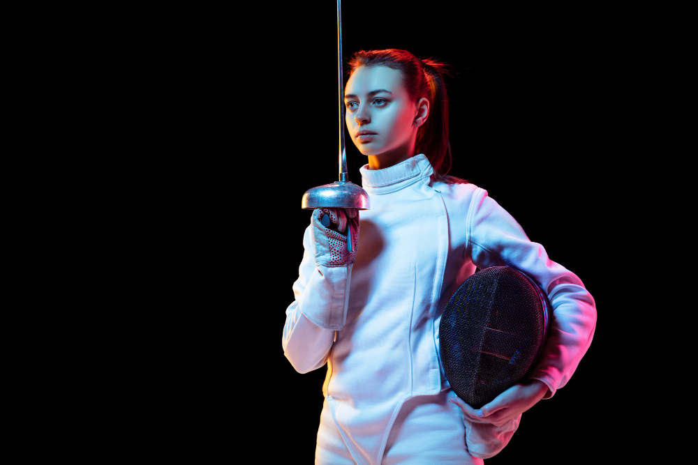teen-girl-in-fencing-costume-with-sword-in-hand-isolated-on-black-background-neon-light.jpg